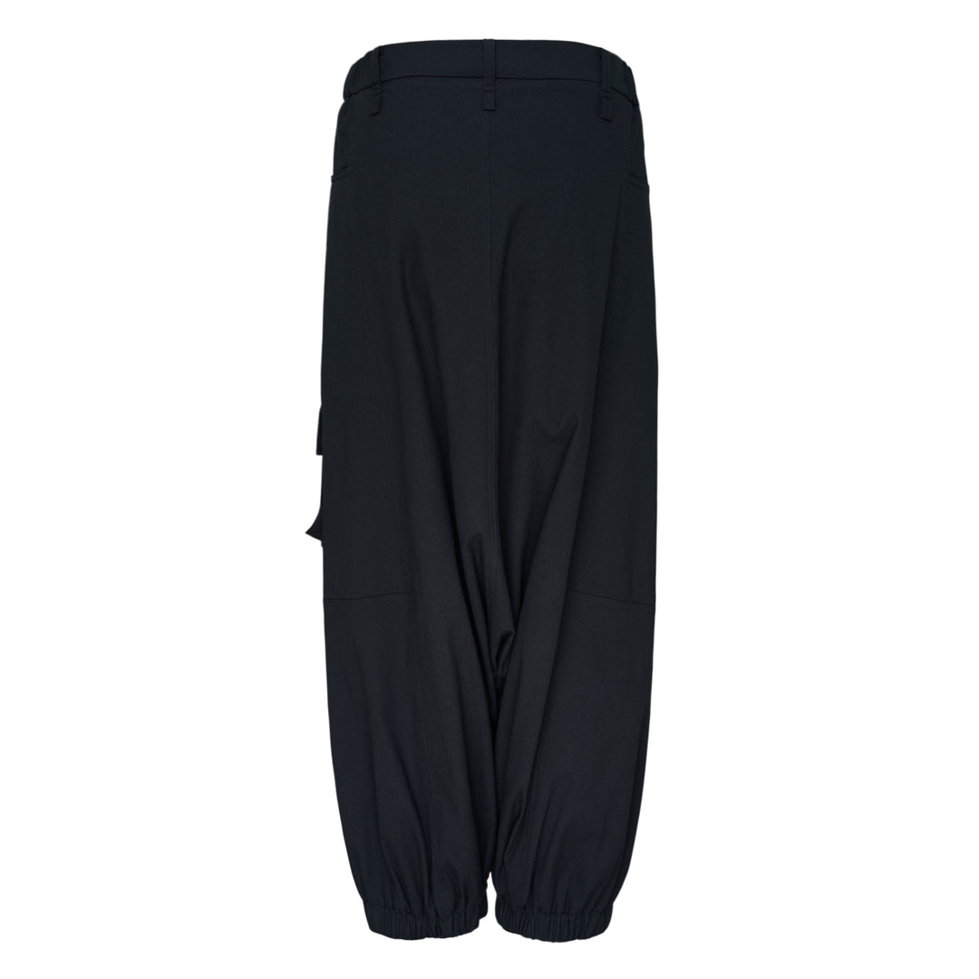 Issey Miyake Grainy Pants in black — wide-leg woven cargo trousers with zip thigh pockets, flap cargo pocket, and button-fastened ankle cuffs