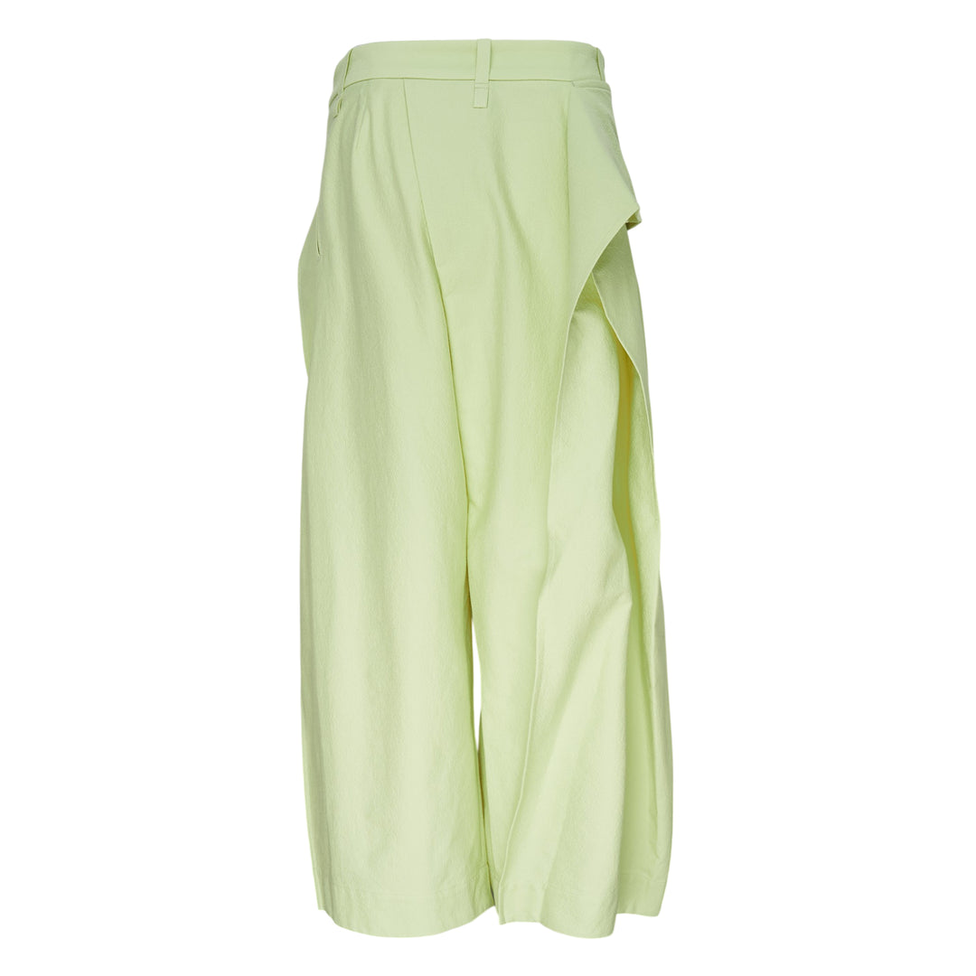 Issey Miyake Grainy Pants in black — wide-leg woven trousers with a fold-over waistband, three-button detail, and asymmetric overlay panel