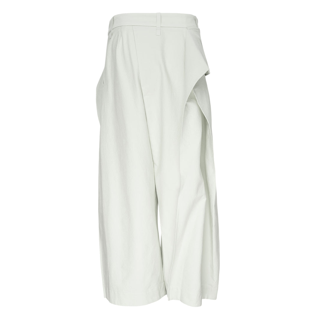 Issey Miyake Grainy Pants in black — wide-leg woven trousers with a fold-over waistband, three-button detail, and asymmetric overlay panel