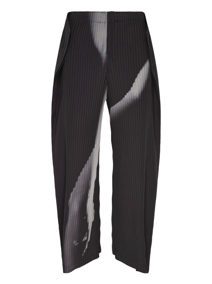 Issey Miyake Hands of Lover Pleats wide-leg cropped pants in black with abstract diagonal grey gradient print across pleated fabric, shown flat on white background
