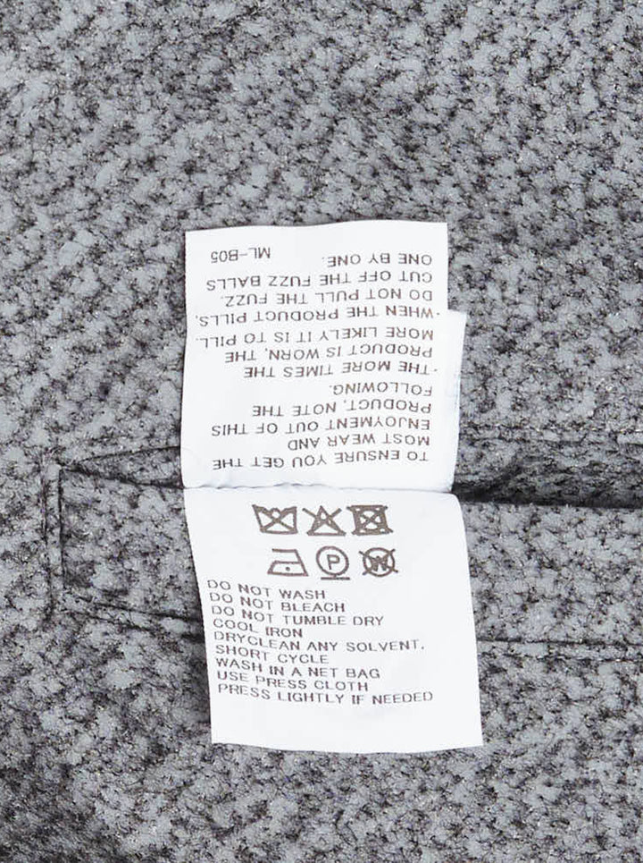 Issey Miyake Reflection woven top in heathered grey, shown flat displaying its asymmetric draped and gathered sculptural silhouette with open-weave textured fabric and visible brand label at neckline - view 3