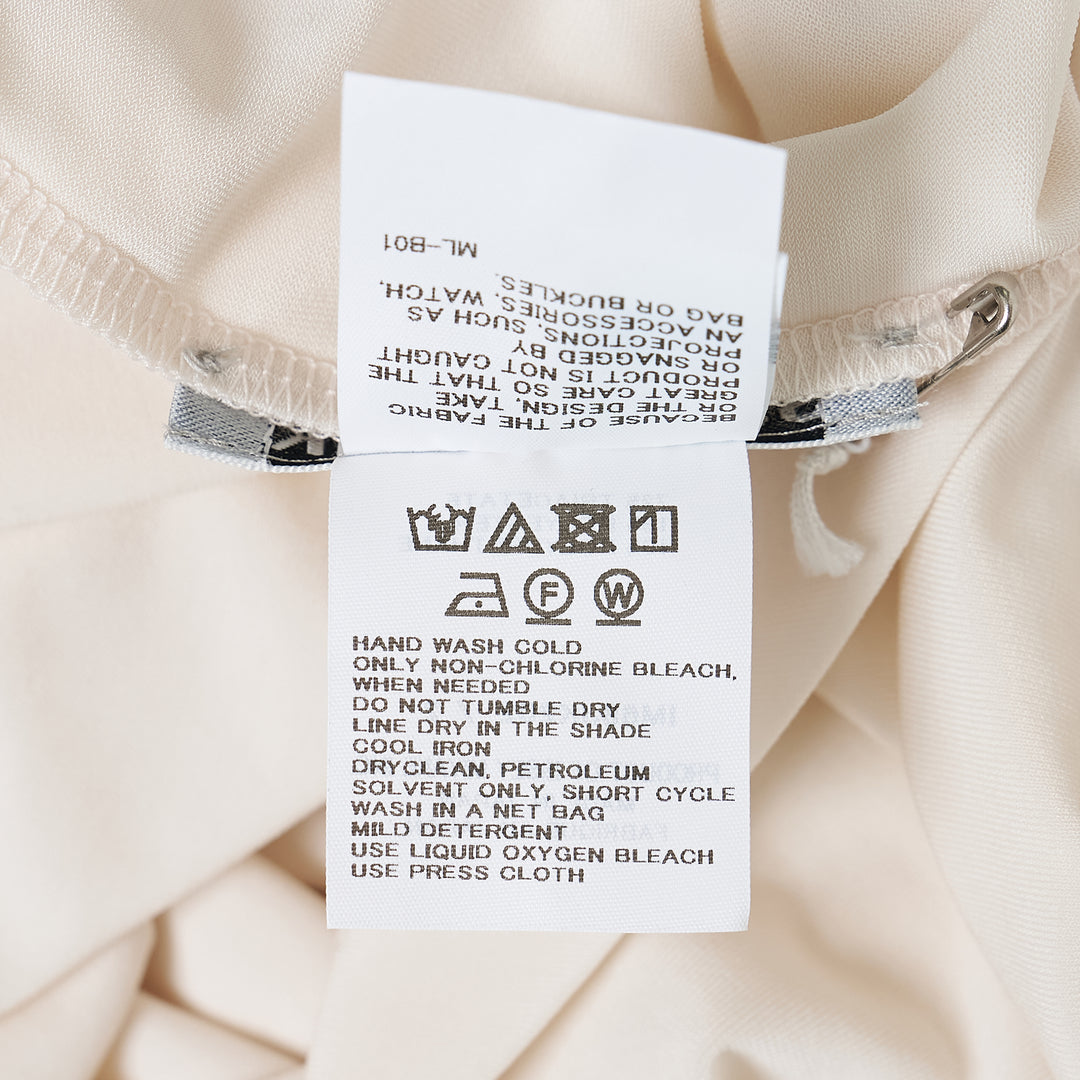 Issey Miyake Drape Jersey Knit Top in black, sleeveless with asymmetric diagonal drape and layered hem, back view on white background