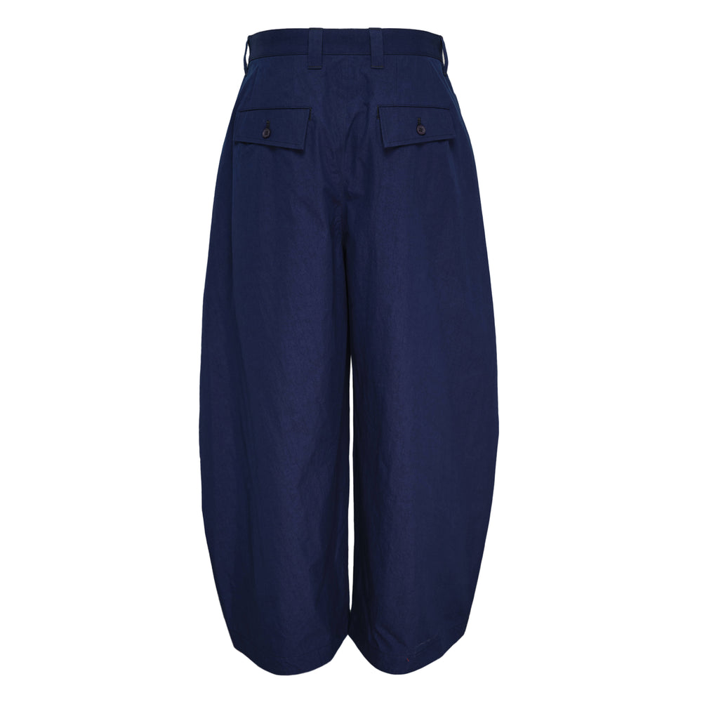 IM Men Overlap Woven Pants in taupe — high-rise wide-leg trousers with draped pleated overlay panels and a balloon-shaped cropped silhouette, front view on white background