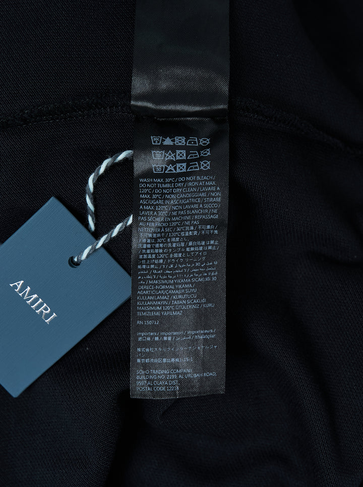 Black Amiri polo shirt with grey eagle and floral embroidery across the shoulders and an embroidered script logo on the chest - view 3