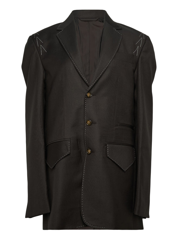 Sonia Carrasco Fundamental Blazer in dark tonal check fabric with white contrast topstitching along lapels and seams, arrow embroidery at shoulders, three antique brass buttons, and patch pockets at hem