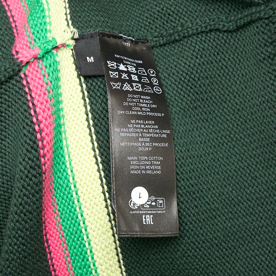 JW Anderson forest green cotton Sheep Jumper with raised intarsia lamb appliqué at the chest and pink, cream, and green stripe bands across the body and sleeves