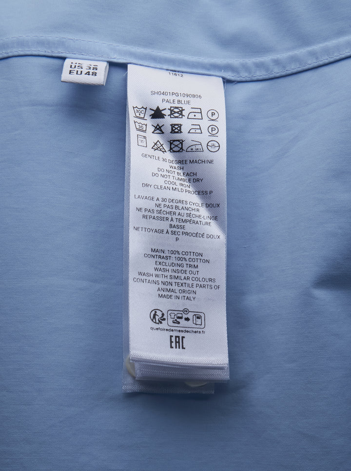 JW Anderson sky blue long-sleeve cotton shirt featuring an oversized black persimmon branch appliqué motif across the front, with white button fastening and point collar - view 3