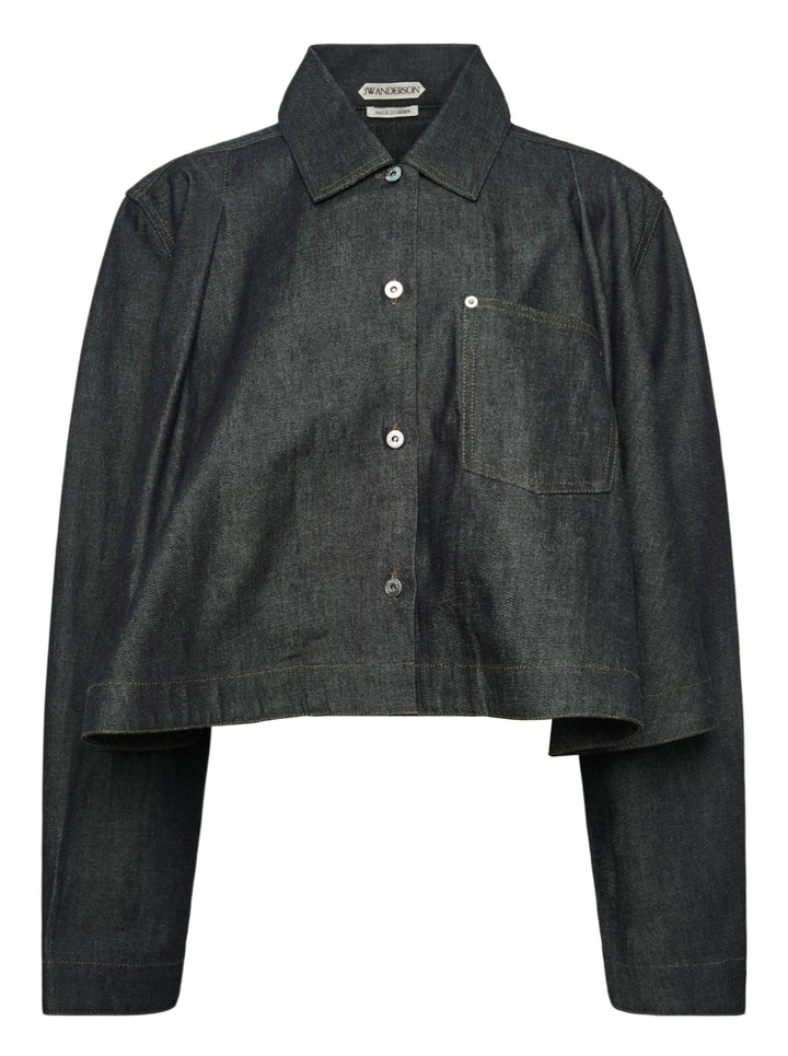 JW Anderson dark indigo lightweight denim flare hem shirt with detached dropped sleeves, cropped body, point collar, patch chest pocket, and mixed mother-of-pearl button fastening — front view