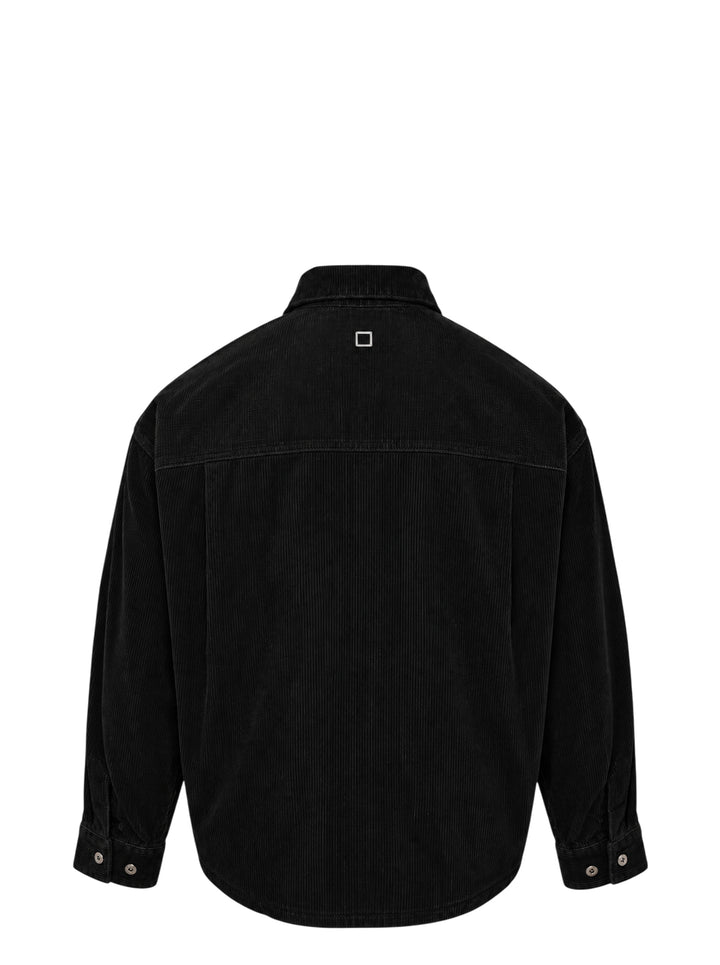 Wooyoungmi Washed Corduroy Overshirt in black, front view, showing ribbed texture, button fastening, chest pocket, and branding label at hem - view 2