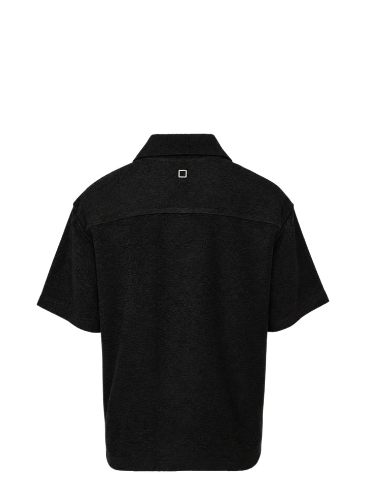 Wooyoungmi Oversized Textured Polo in black, featuring an open-placket collar, boxy short-sleeve silhouette, chest patch pocket with tonal WM monogram badge, and side hem vents - view 2