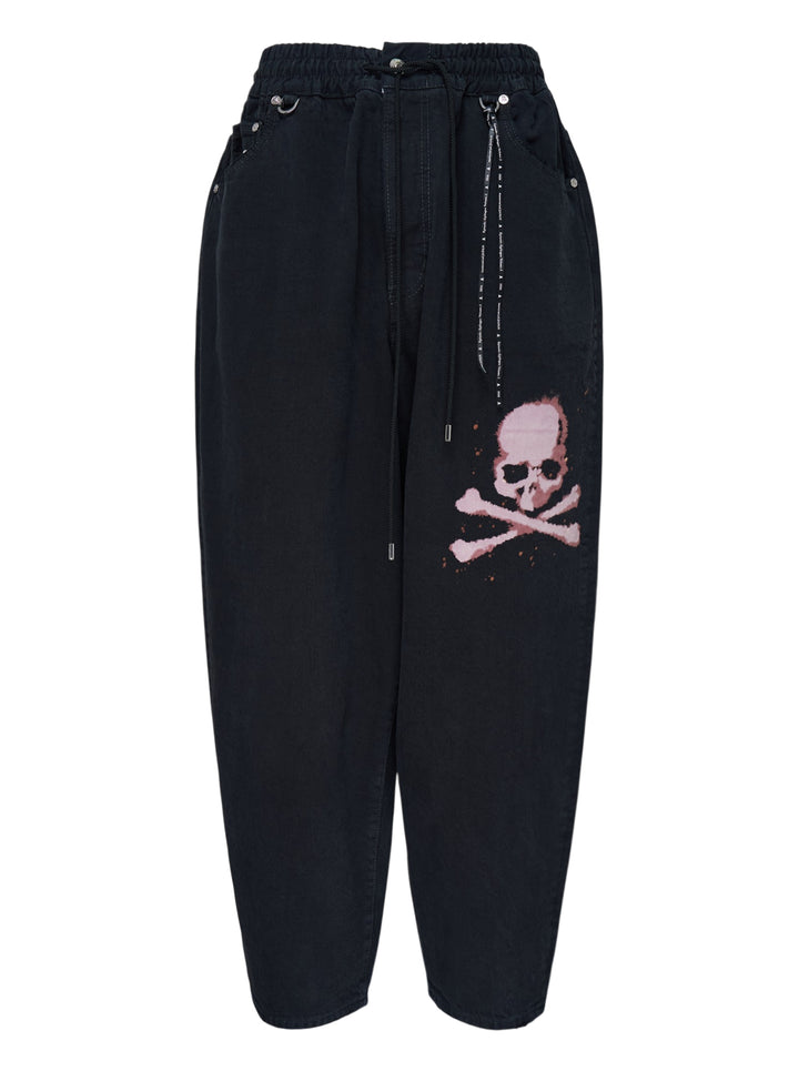 Mastermind wide easy denim pants in washed black with a pink skull and crossbones graphic, drawcord waist and metal D-ring details
