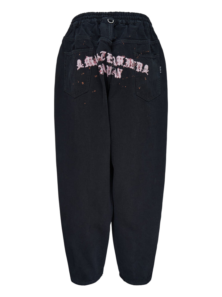 Mastermind wide easy denim pants in washed black with a pink skull and crossbones graphic, drawcord waist and metal D-ring details - view 2