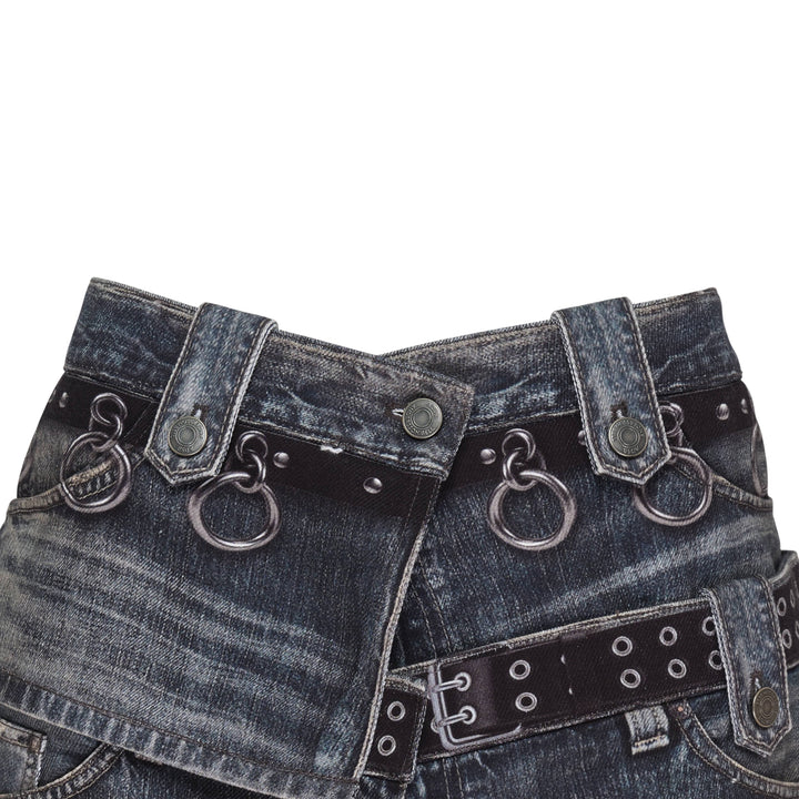 Andersson Bell Asymmetric Layered Wrap Skirt in washed indigo denim with studded belt straps, silver O-ring hardware, exposed zip, and contrast black layered hem
