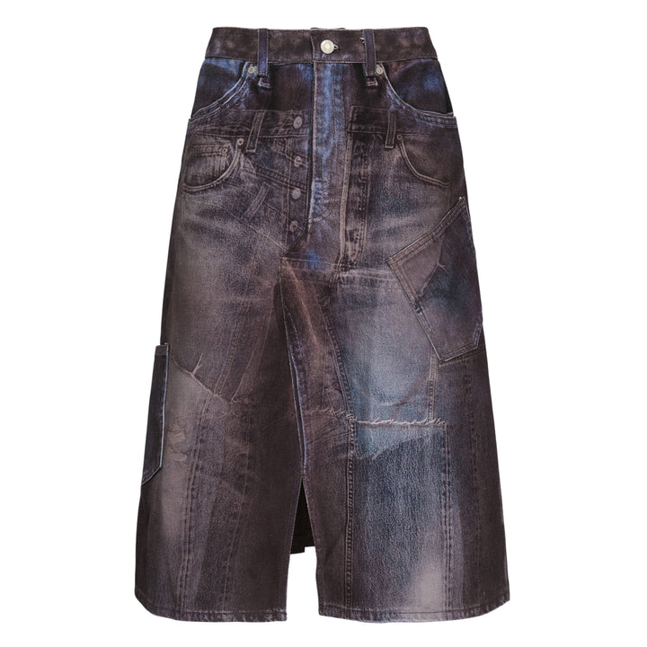 Andersson Bell Illusion Patchwork Denim Skirt with trompe l'œil patchwork print, high waist, silver-tone button closure, and pleated underlay hem on a white background