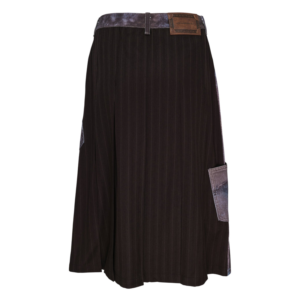 Andersson Bell Illusion Patchwork Denim Skirt with trompe l'œil patchwork print, high waist, silver-tone button closure, and pleated underlay hem on a white background