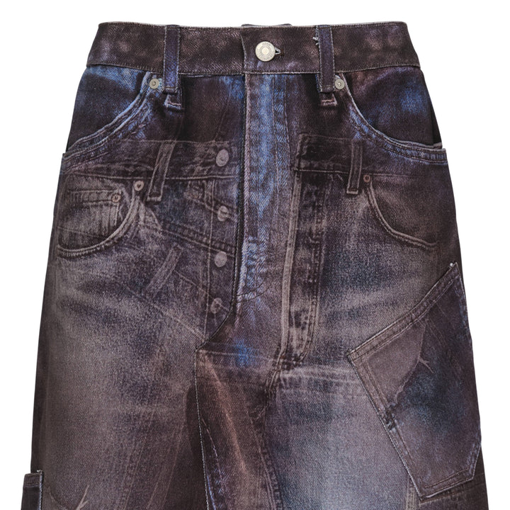 Andersson Bell Illusion Patchwork Denim Skirt with trompe l'œil patchwork print, high waist, silver-tone button closure, and pleated underlay hem on a white background
