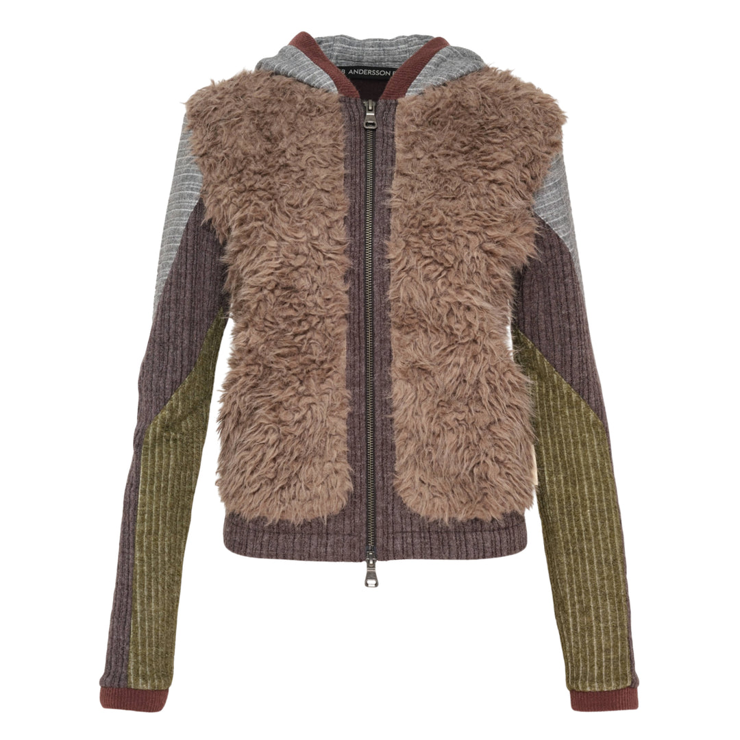 Andersson Bell faux fur color-blocked hooded zip-up sweater with taupe fur front panel, patchwork ribbed knit sleeves in grey charcoal and olive, striped hood with burgundy trim, and full-length zip closure — flat lay on white background