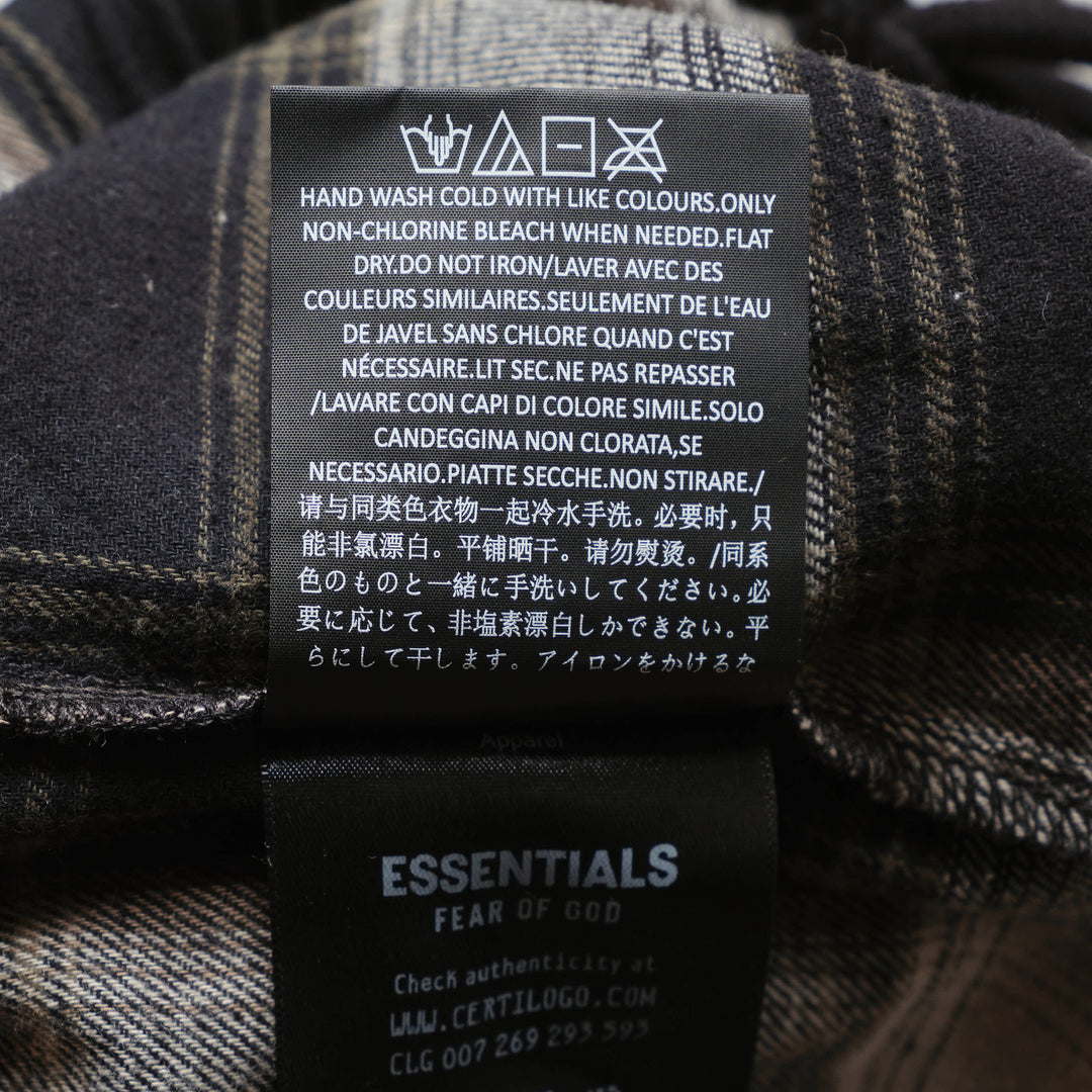 Fear of God Essentials Plaid Lounge Pants in black and cream windowpane check with wide-leg silhouette and elasticated drawstring waistband, flat lay on white background