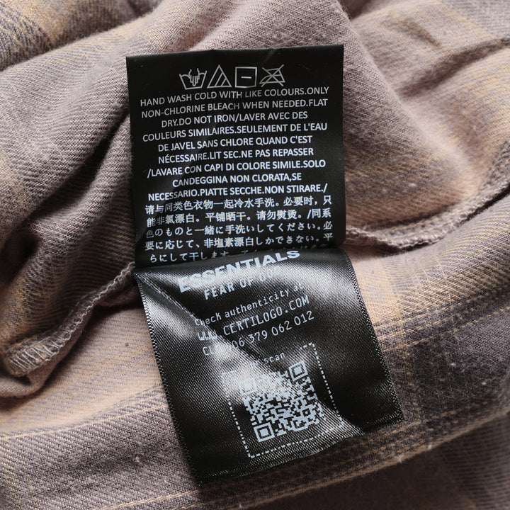 Fear of God Essentials Plaid Lounge Pants in black and cream windowpane check with wide-leg silhouette and elasticated drawstring waistband, flat lay on white background