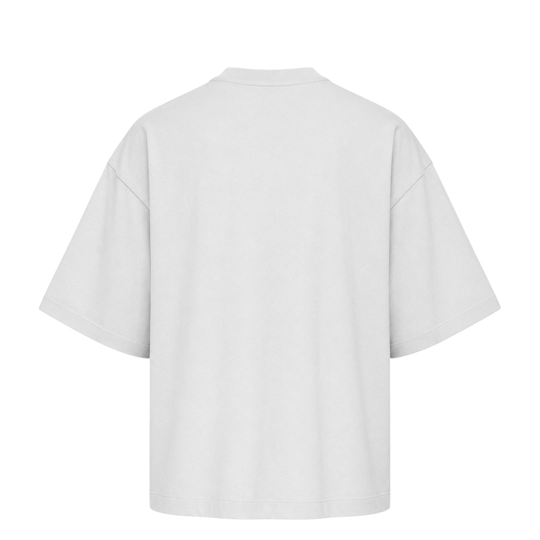 Fear of God Essentials Merch Tee in washed charcoal, featuring a boxy oversized silhouette, dropped shoulders, tonal chest branding patch, and a mock-neck collar