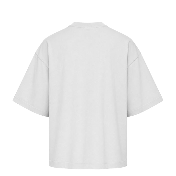 Fear of God Essentials Merch Tee in washed charcoal, featuring a boxy oversized silhouette, dropped shoulders, tonal chest branding patch, and a mock-neck collar