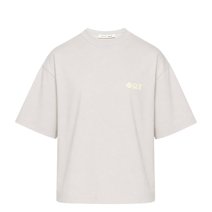 Fear of God Essentials Merch Graphic Tee in blue-grey with tonal Greek-letter chest print, displayed flat on a white background