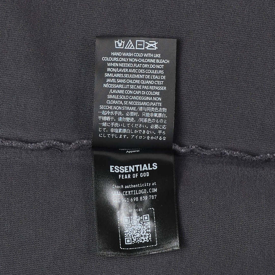 Fear of God Essentials F26 Cropped Polo in washed charcoal with tonal F26 puff-print branding on the chest, featuring a spread collar, concealed placket, and dropped-shoulder half sleeves