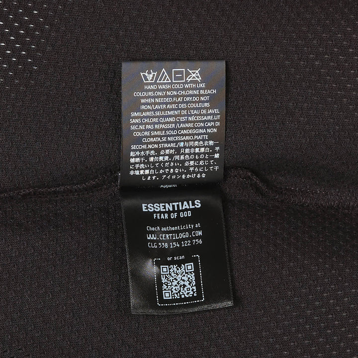 Fear of God Essentials All Valley Essentials Merch Tee in black, featuring a perforated mesh fabric, tonal arch graphic across the chest, and an oversized boxy silhouette with a ribbed mock-neck collar