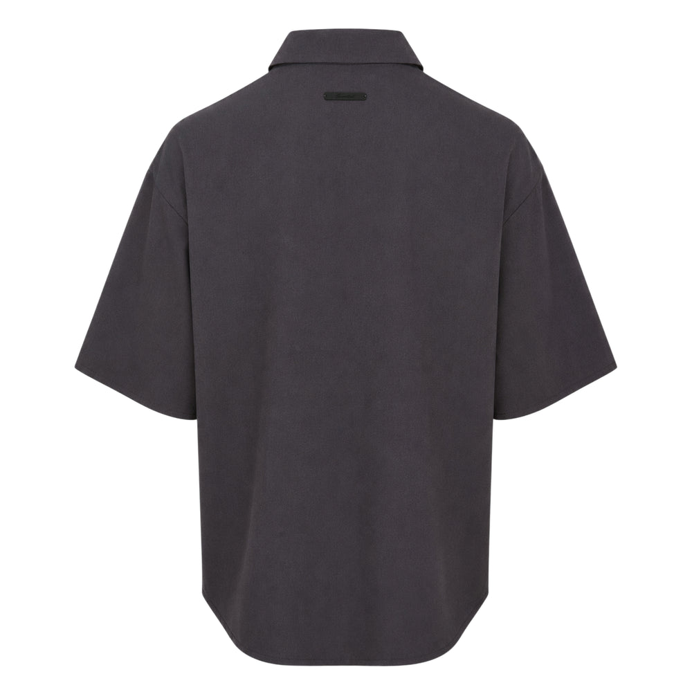 Fear of God Essentials short sleeve button up shirt in black, featuring a boxy oversized silhouette, point collar, and tonal button placket, displayed flat on a white background