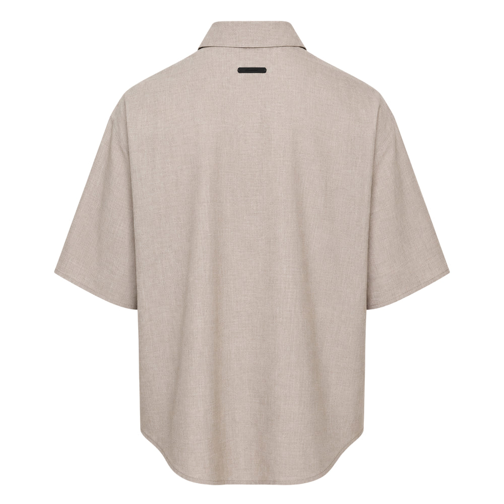 Fear of God Essentials short sleeve button up shirt in black, featuring a boxy oversized silhouette, point collar, and tonal button placket, displayed flat on a white background