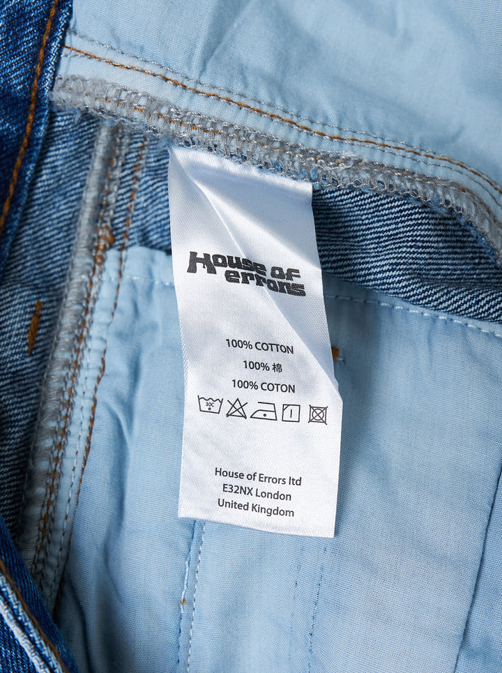 House of Errors Crown Jeans in mid-wash blue denim with whiskered fading, wide-leg cut and gold-tone engraved button, shown flat from the front - view 5