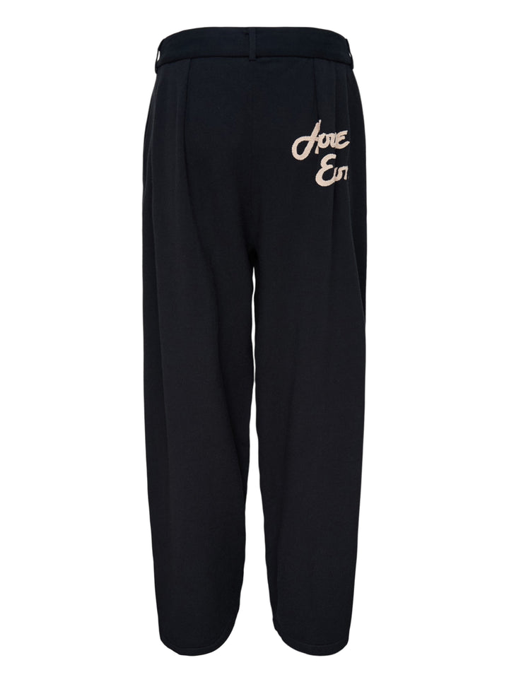 Black knitted pleated trousers with a high banded waist, button fastening and a small embroidered cat burglar motif at the hem - view 2