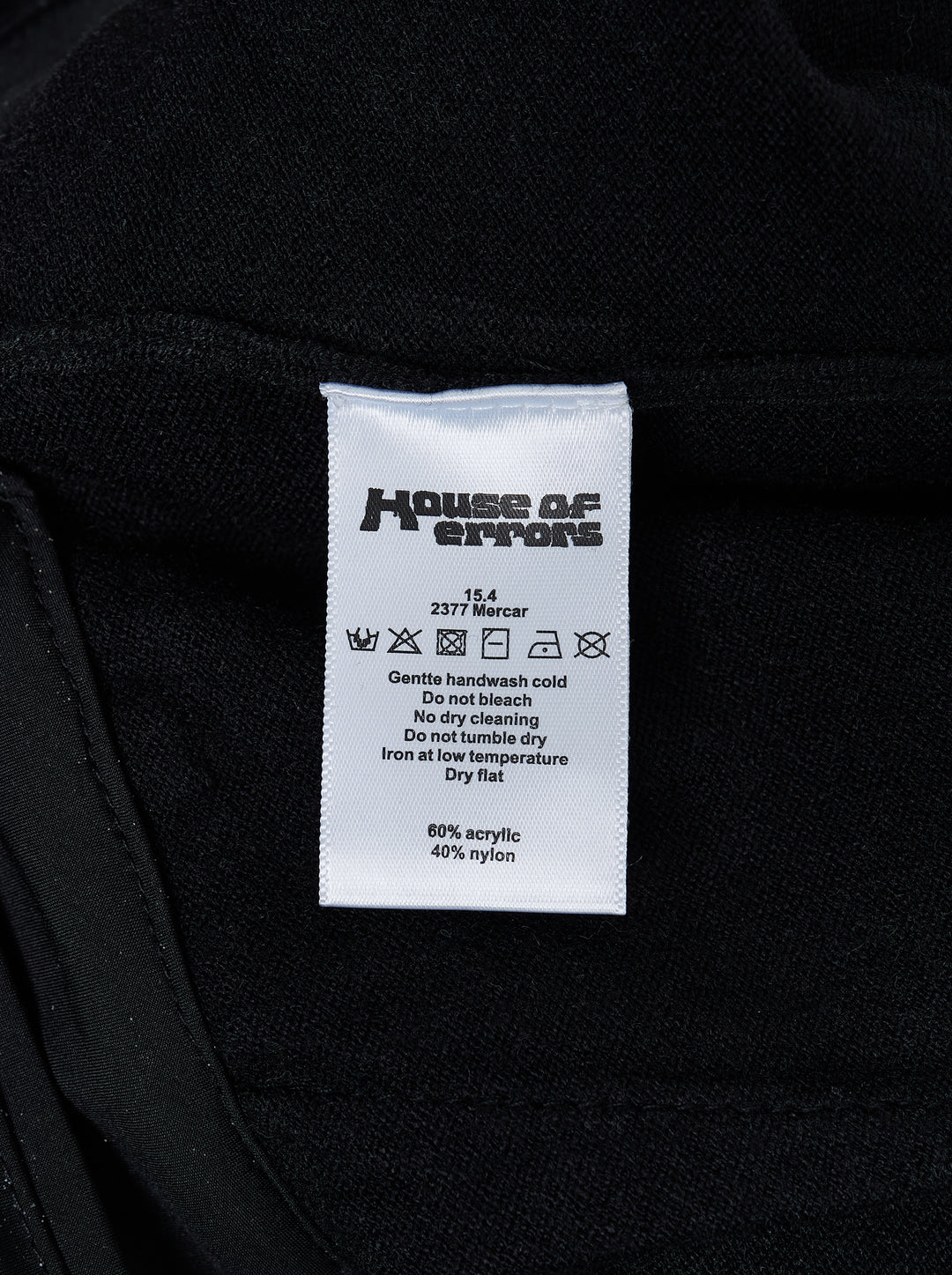 Black knitted pleated trousers with a high banded waist, button fastening and a small embroidered cat burglar motif at the hem - view 5