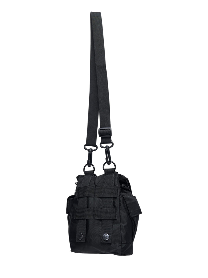 Human Made Military Pouch #1 in black nylon, featuring woven webbing harness, dual D-ring attachments, buckle-release closure, and a detachable adjustable shoulder strap, shown on a white background - view 2