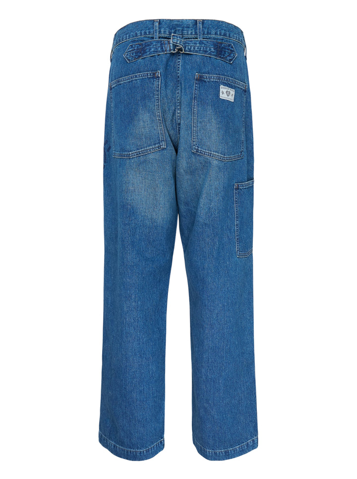 Human Made baggy denim pants in washed mid-blue with oversized patch pockets and a heart logo print on the leg, shown from the front - view 2