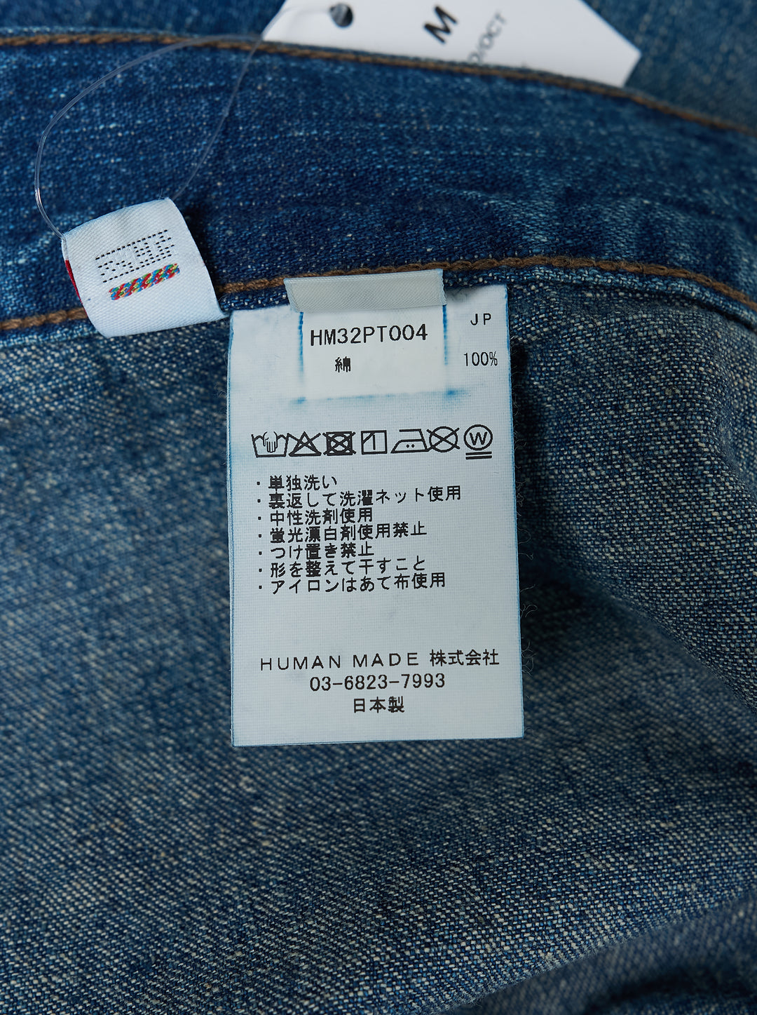 Human Made baggy denim pants in washed mid-blue with oversized patch pockets and a heart logo print on the leg, shown from the front - view 4