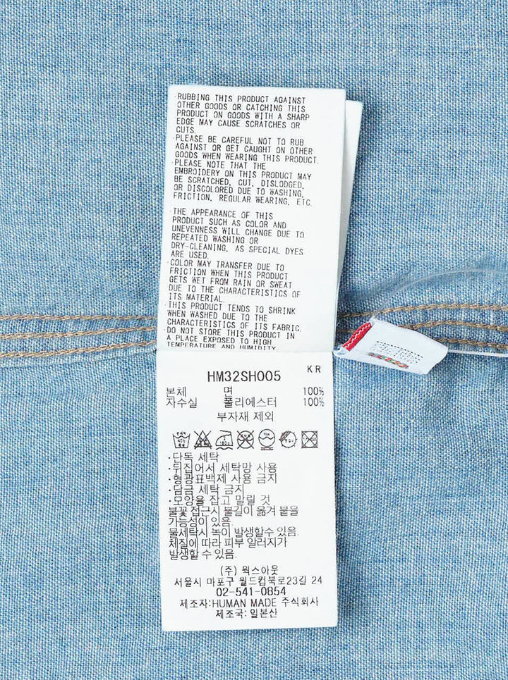 Human Made Embroidered Long Sleeve Chambray Shirt in light-wash denim, featuring a flying duck and deer head embroidery above dual chest pockets, with amber buttons and Human Made script embroidery - view 5