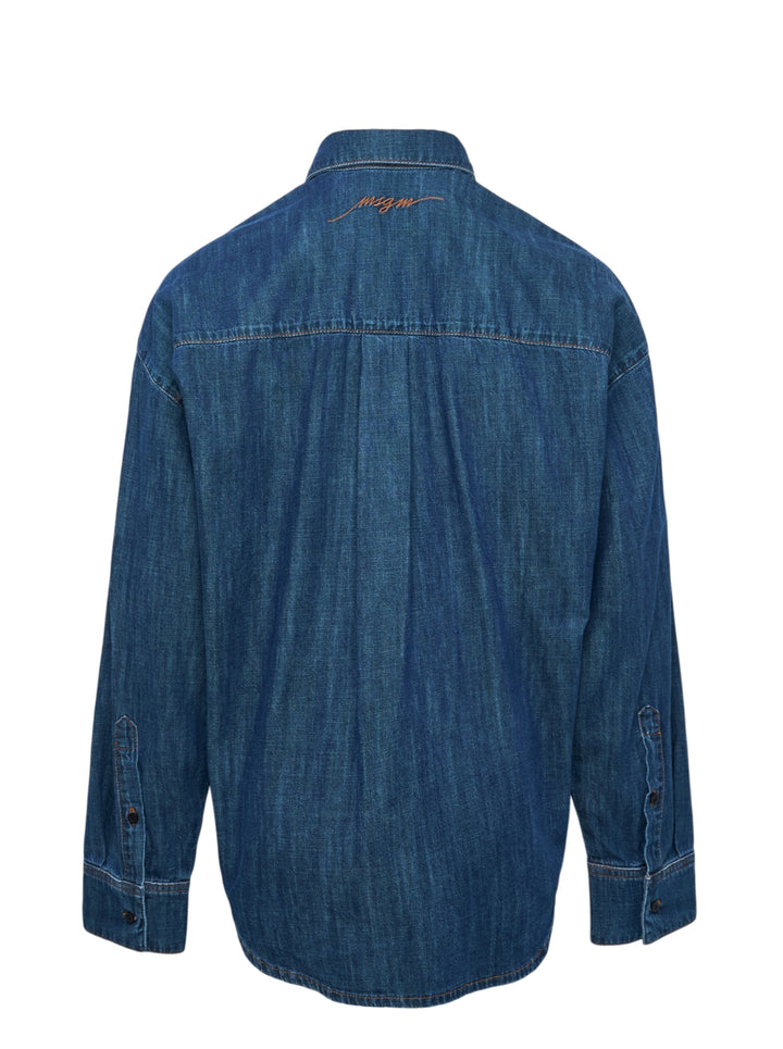 MSGM indigo denim blouse with sculptural attached bowtie bib, button-down collar, full button placket, and wide double cuffs, displayed flat on a white background - view 2