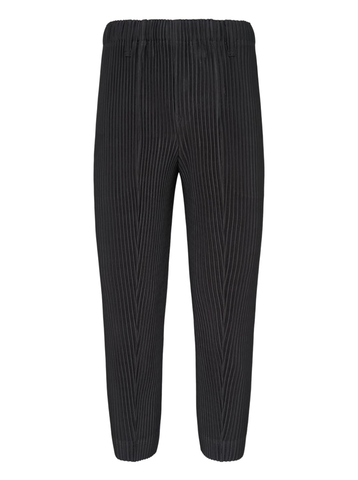 Homme Plissé Issey Miyake Compleat Pleated Trousers in black, shown flat with all-over permanent pleating and elasticated waistband
