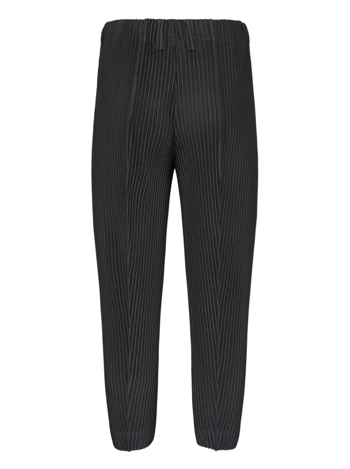 Homme Plissé Issey Miyake Compleat Pleated Trousers in black, shown flat with all-over permanent pleating and elasticated waistband - view 2