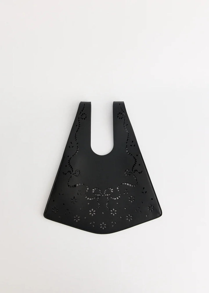 Simone Rocha mini shopper bag in black leather with lasercut lace-inspired bow and floral cutouts, shown flat against a white background - view 2