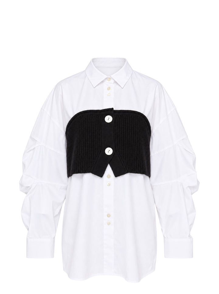 Enfold Knitted Docking Shirt — white cotton poplin long-sleeve shirt with integrated black ribbed knit bandeau panel featuring mother-of-pearl buttons and ruched sleeves, flat lay on white background