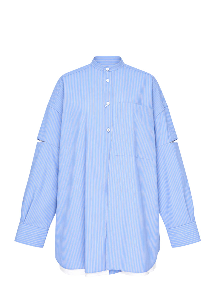 Enfold pale blue pinstripe oversized shirt with deconstructed cut-out sleeves, mandarin collar, white button placket, and a contrast white underlayer at the hem