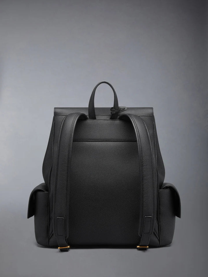 Thom Browne Bolton backpack in black soft pebble leather with brass-tone lock closure, flap side pockets, and red, white, and blue tab detail - view 2