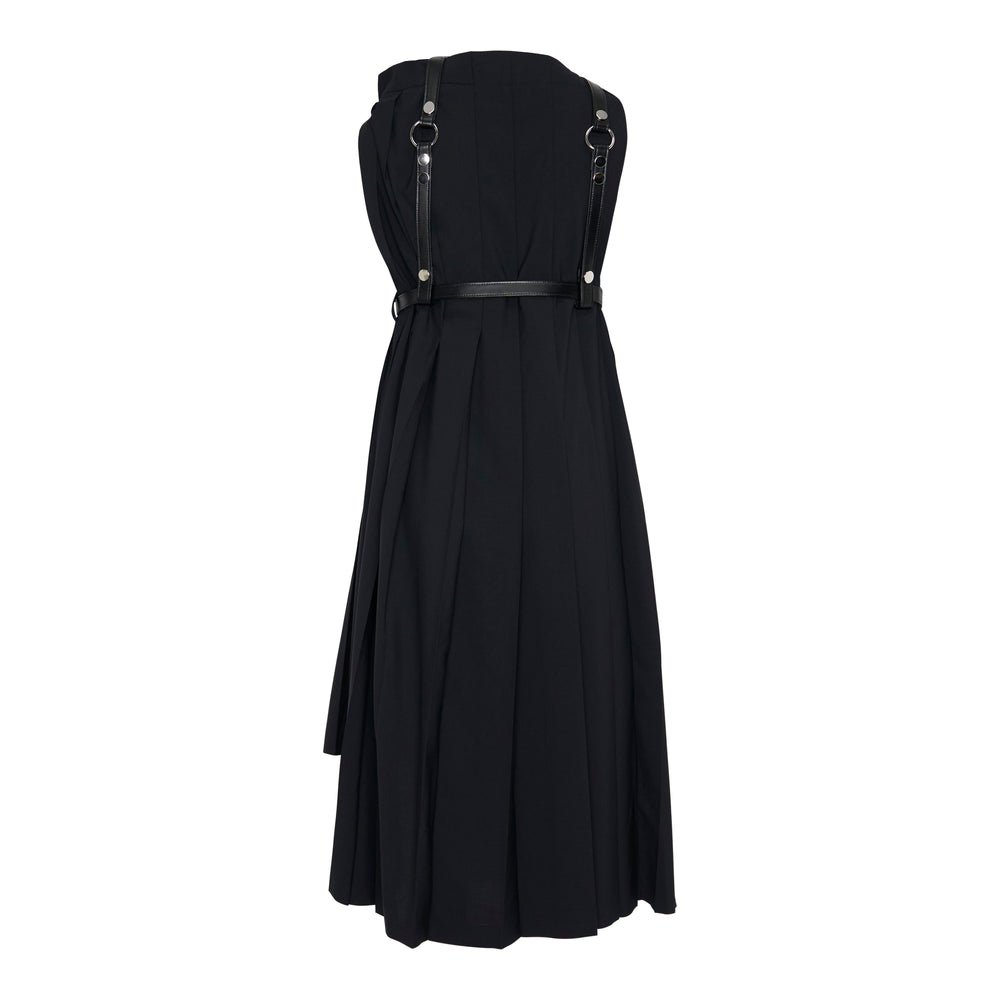 Junya Watanabe black midi pleated dress with integrated leather harness, silver-tone hardware, belted waist, and asymmetric hem, displayed on a ghost mannequin against a white background