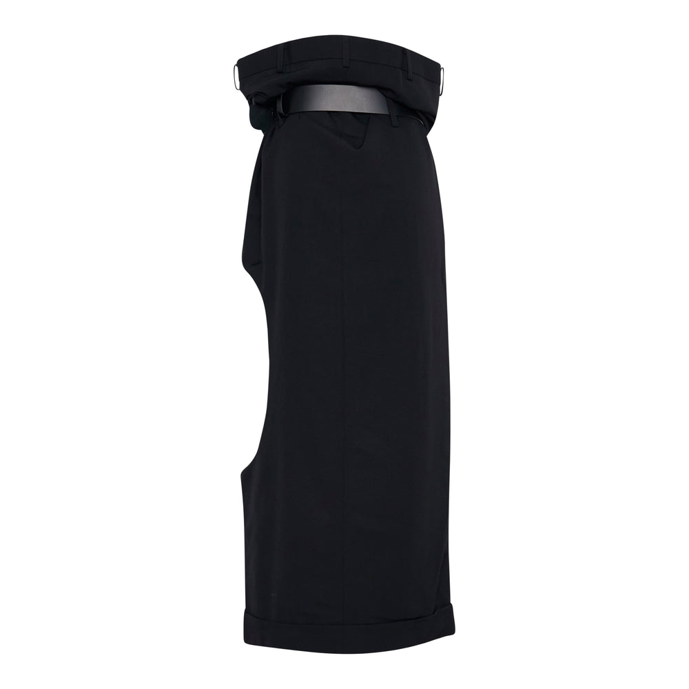 Junya Watanabe long sculptural draped black midi skirt with deconstructed trouser waistband, leather belt with pin buckle, D-ring hardware, and asymmetric side cutout — side view on white background