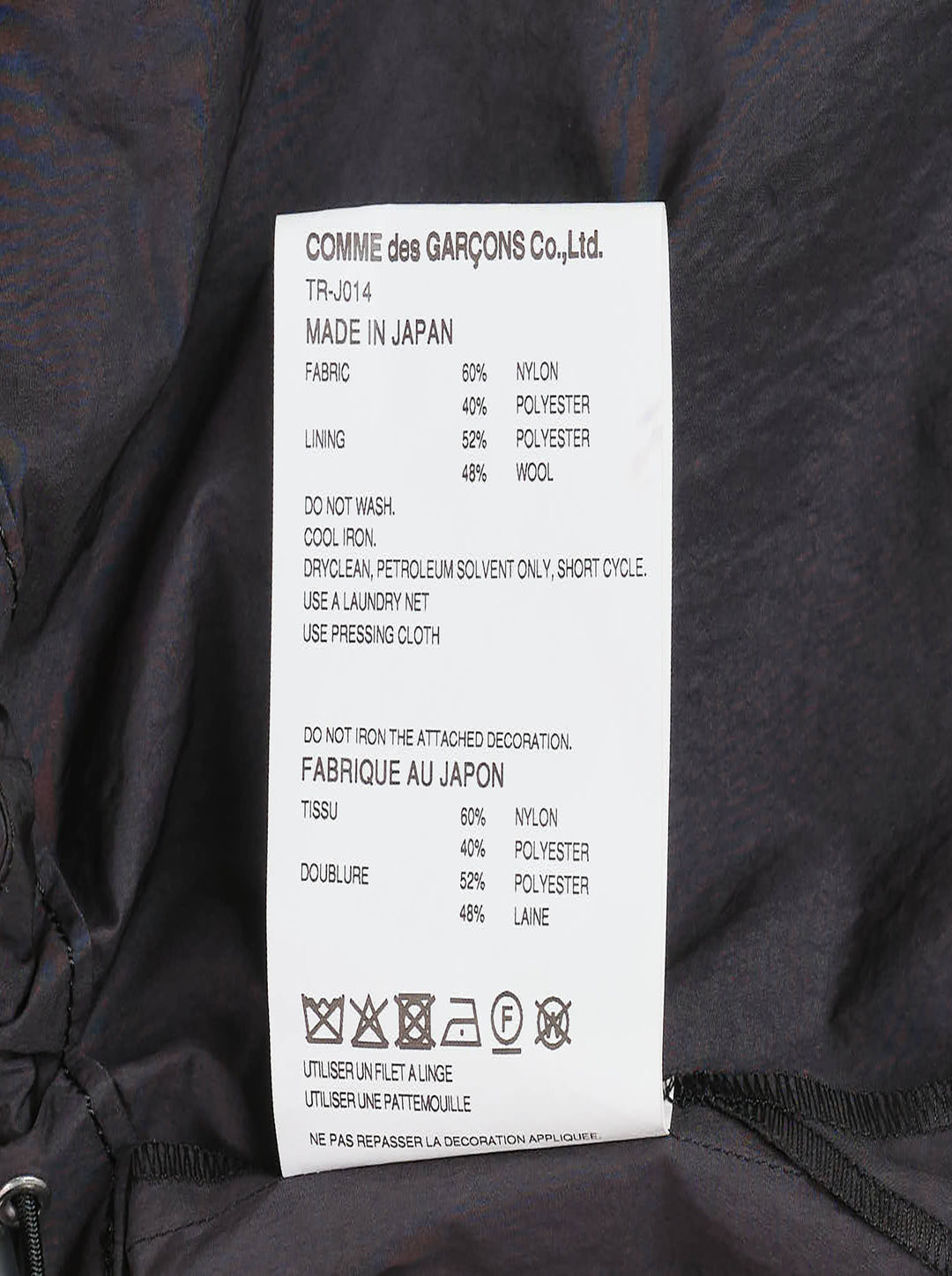 Tao structured cape top in dark charcoal with an oversized gathered bow at the neckline, patch pockets, and a drawstring elasticated hem, displayed on a plain white background - view 3