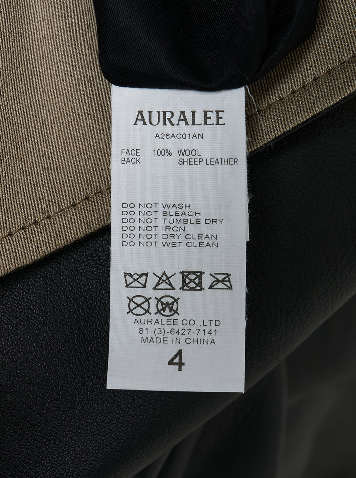 Auralee reversible wool twisted twill coat in beige with stand collar, button front and black leather reverse visible at the collar - view 5