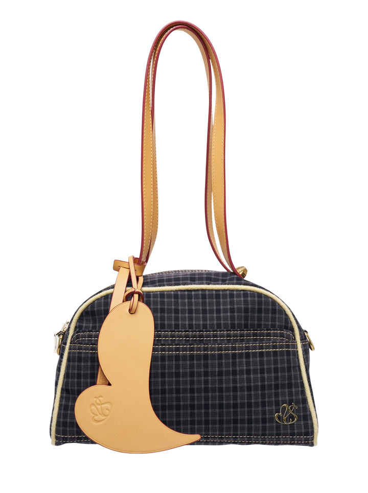 Sultry Virgin Gingham Bowling Bag in dark plaid fabric with tan leather trim, cream topstitching, bird-shaped charm pendant, and a dual-tone shoulder strap with red painted edge