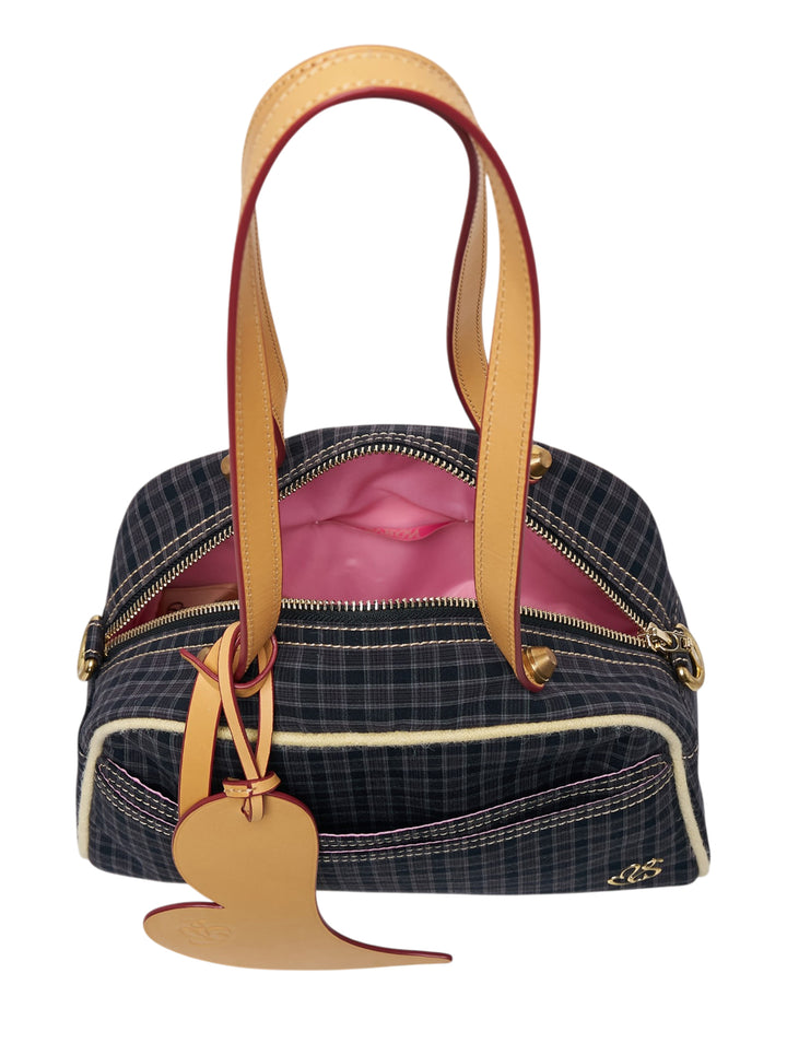 Sultry Virgin Gingham Bowling Bag in dark plaid fabric with tan leather trim, cream topstitching, bird-shaped charm pendant, and a dual-tone shoulder strap with red painted edge - view 3
